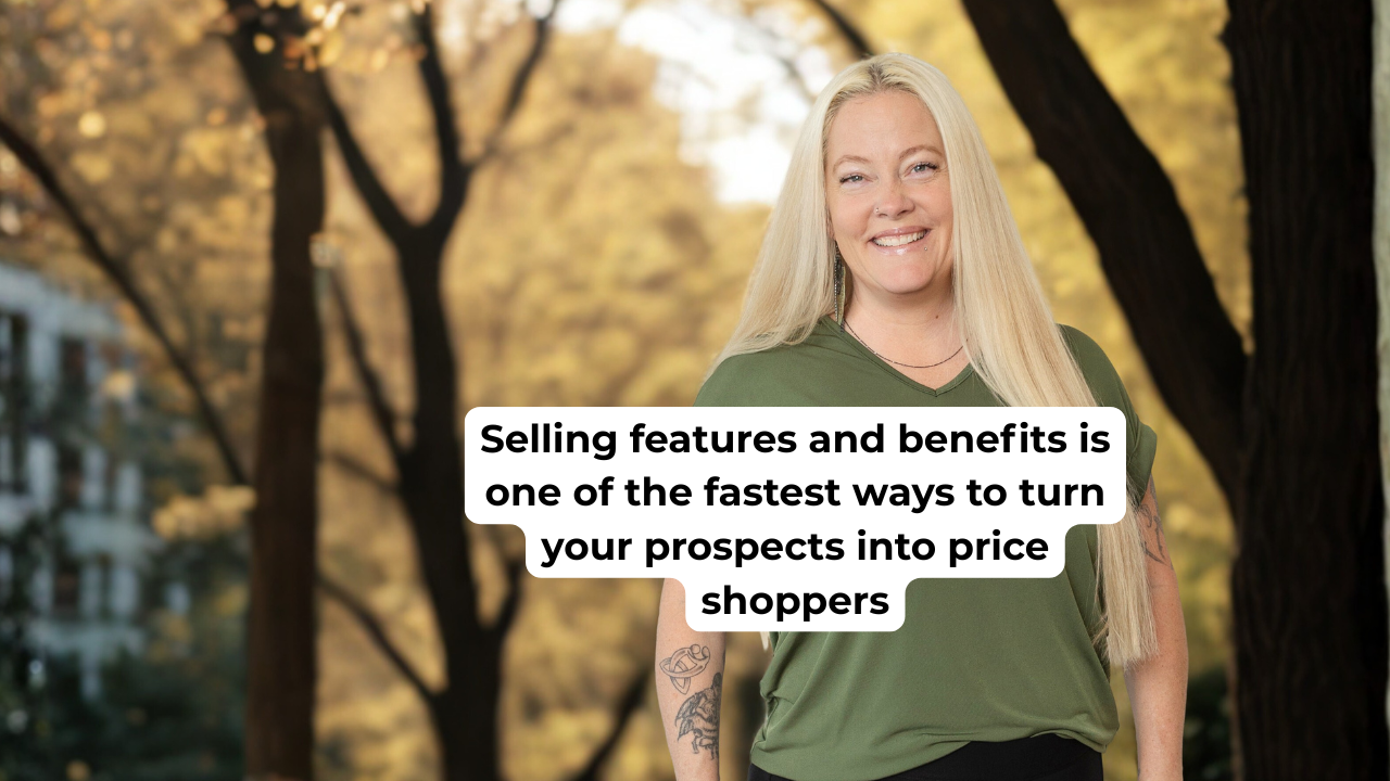 Woman in green shirt smiling in front of fall colored trees