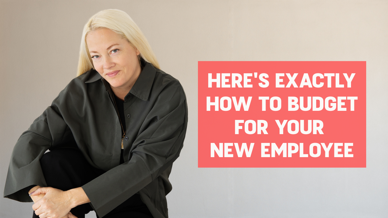 Woman wearing a grey jacket, smiling, and her arms crossed over her legs smiling with words on the screen that say "Here's Exactly How to Budget for Your New Employee"