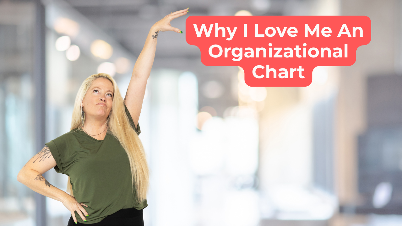 Woman wear an olive green shirt pointing at words on screen that say, "Why I Love Me An Organizational Chart"