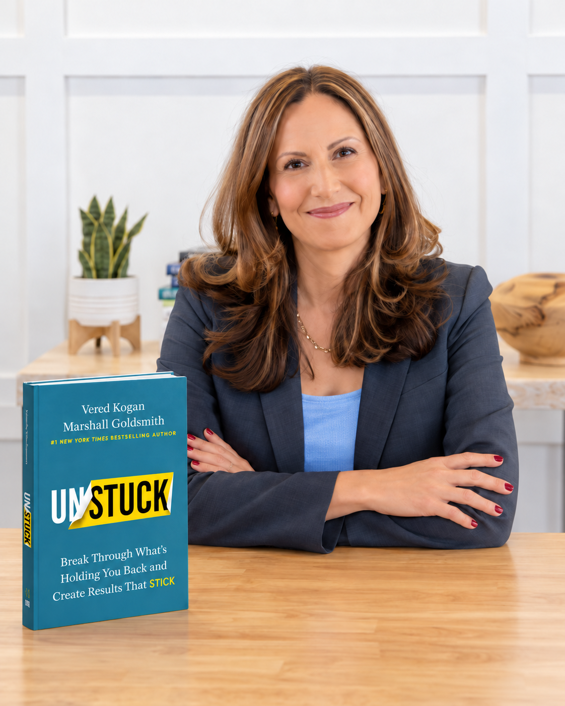 Vered Kogan seated beside the UNSTUCK book