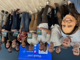 Vered Kogan with a group of attendees holding UNSTUCK books