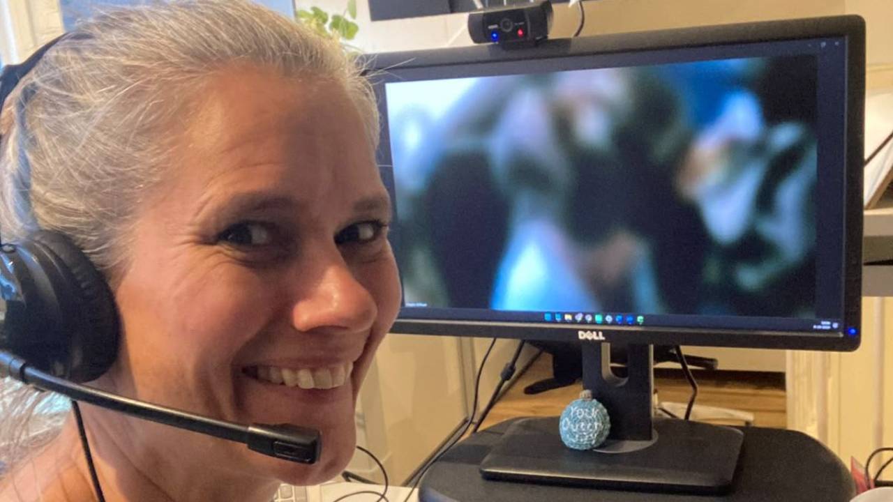 Maayke behind her laptop, with headset. Ready to talk Dutch with clients