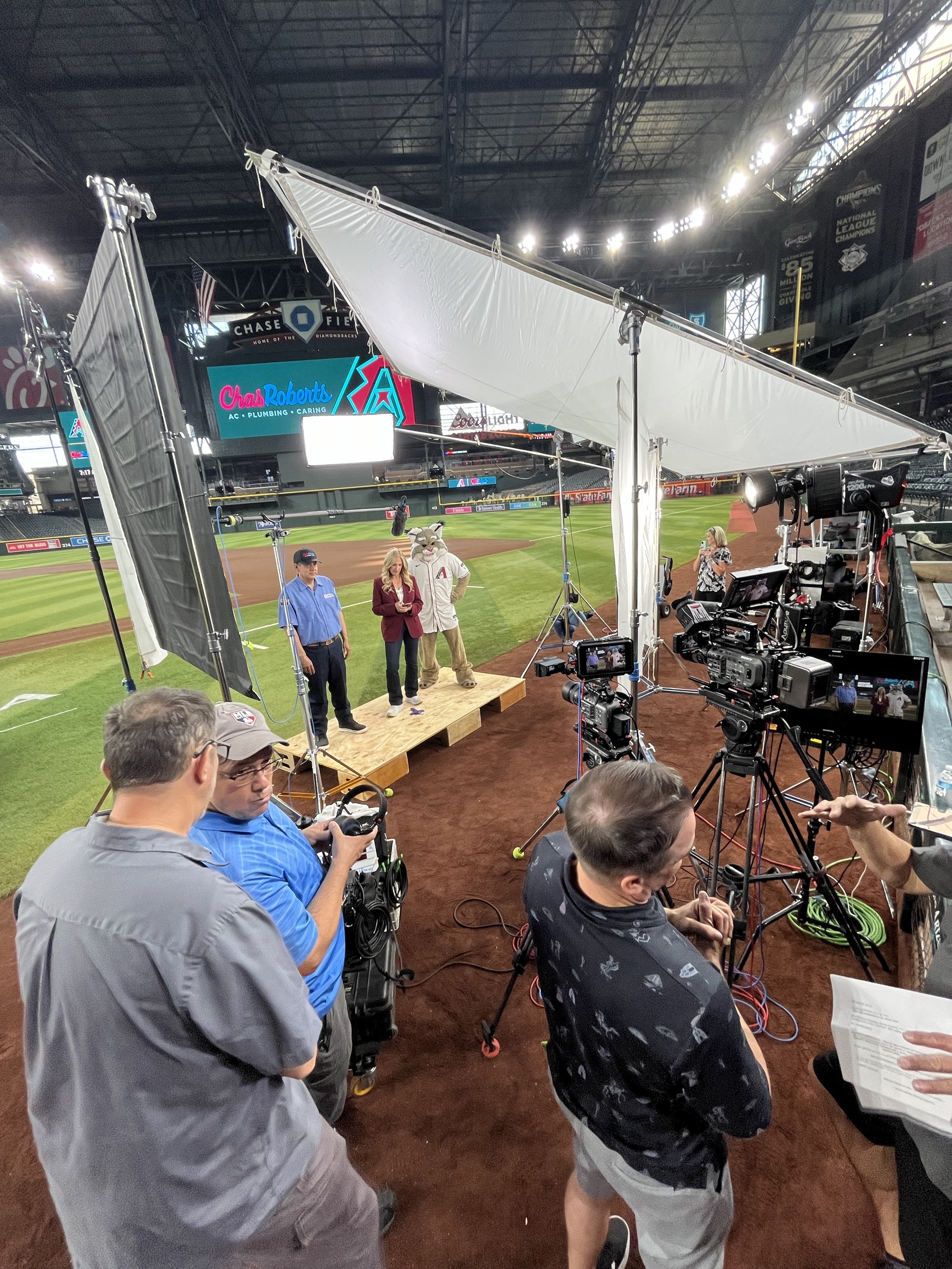 Large stadium lighting setup with overhead diffusion, high-output fixtures, and negative fill