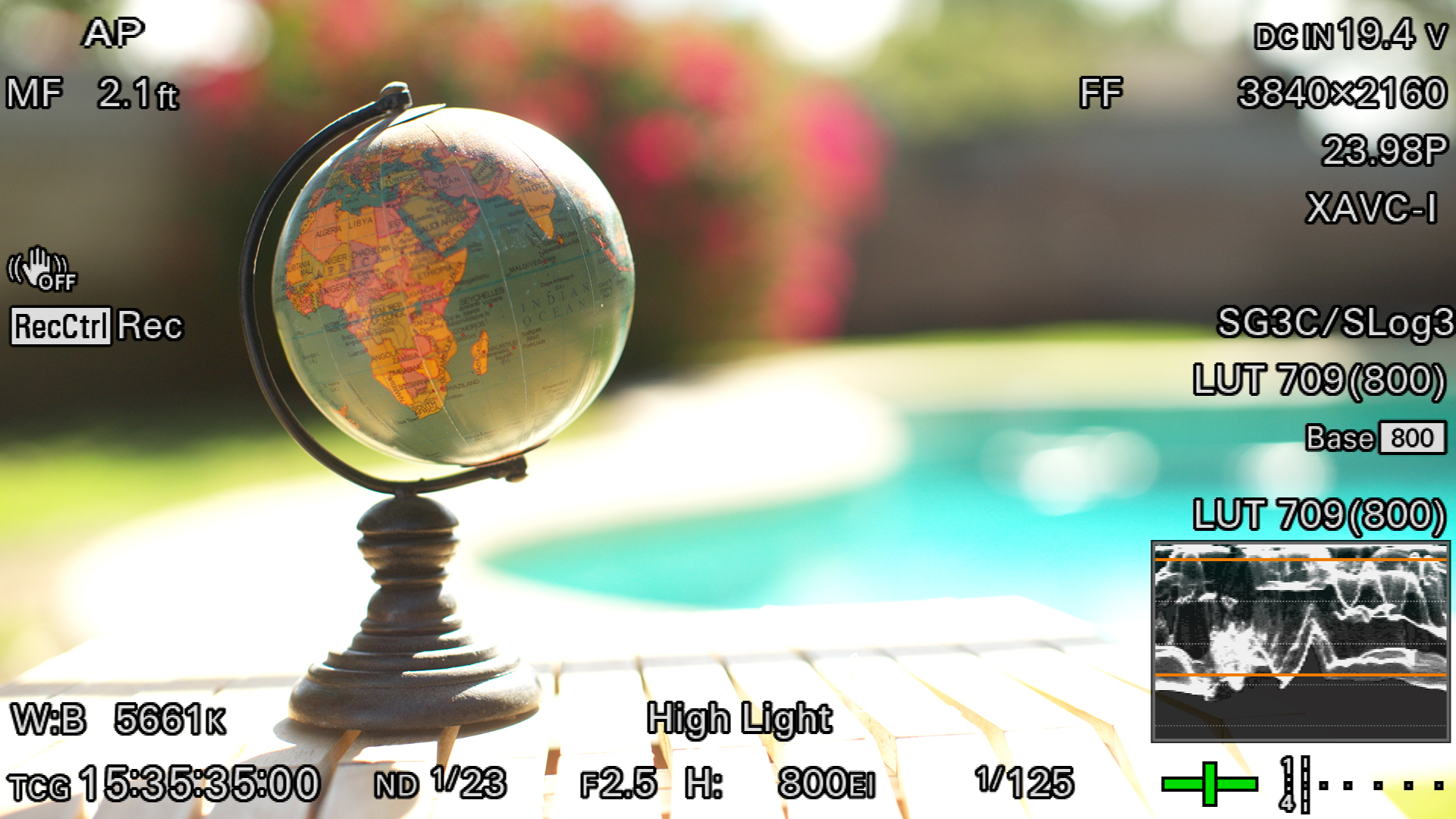 Globe and wooden table in harsh direct sunlight before outdoor lighting control
