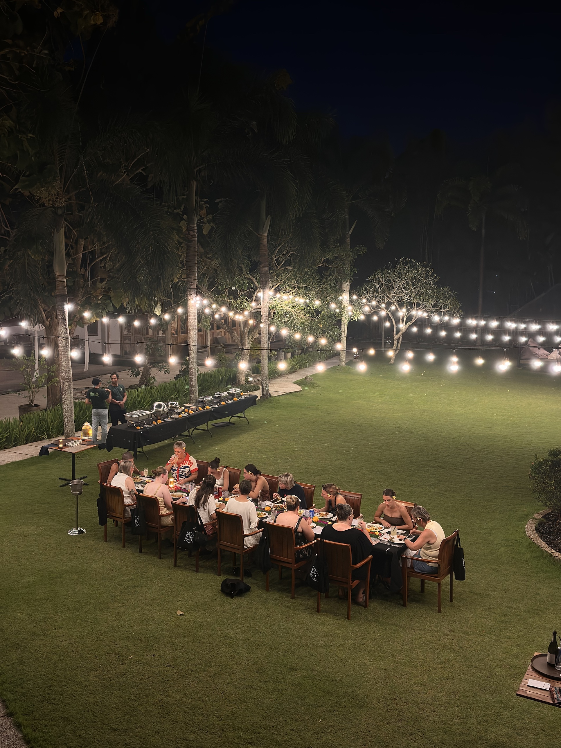 Long table outdoor dinner under string lights at RECHARGE Bali women's retreat