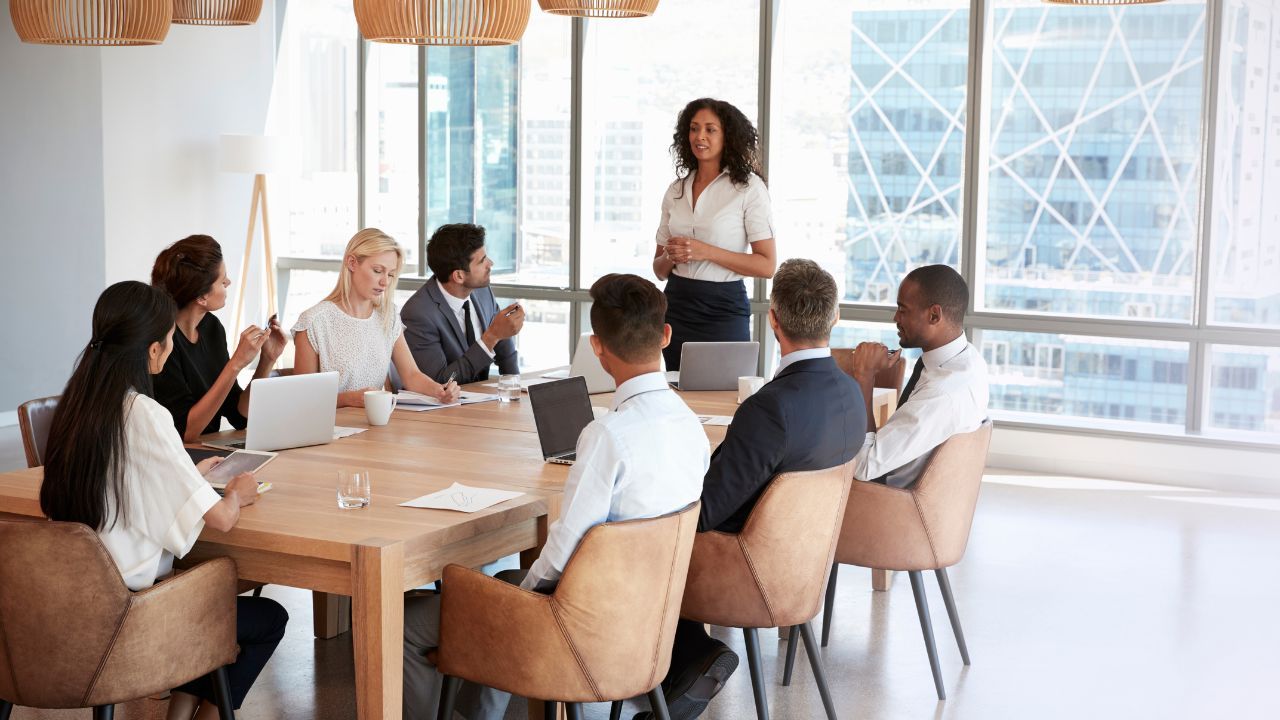 A woman standing composed in a professional meeting, representing the experience of microaggressions at work
