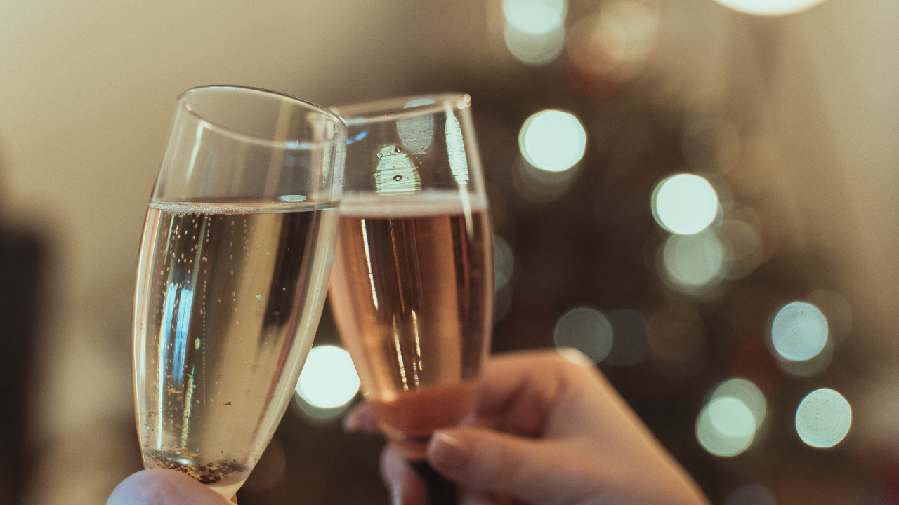 A person raising a glass to give a toast at a celebration, representing speaking confidently at special occasions