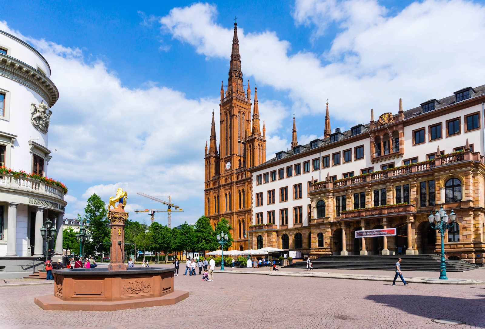 Marktkirche and the city hall on a sunny square in Wiesbaden, Germany, with a fountain in the foreground