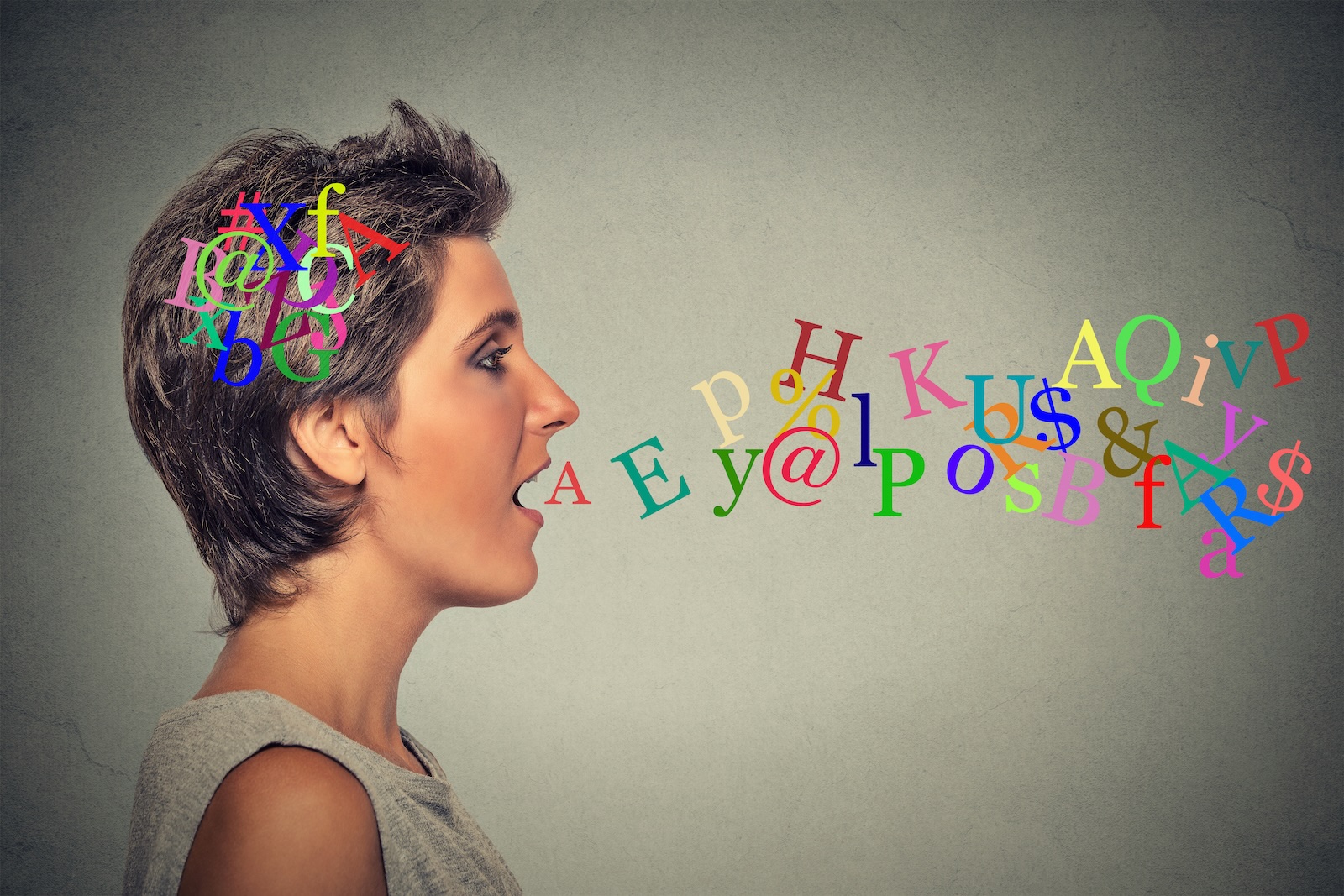 Woman in profile with colorful letters swirling in her head and flowing from her mouth, as if speaking a new language