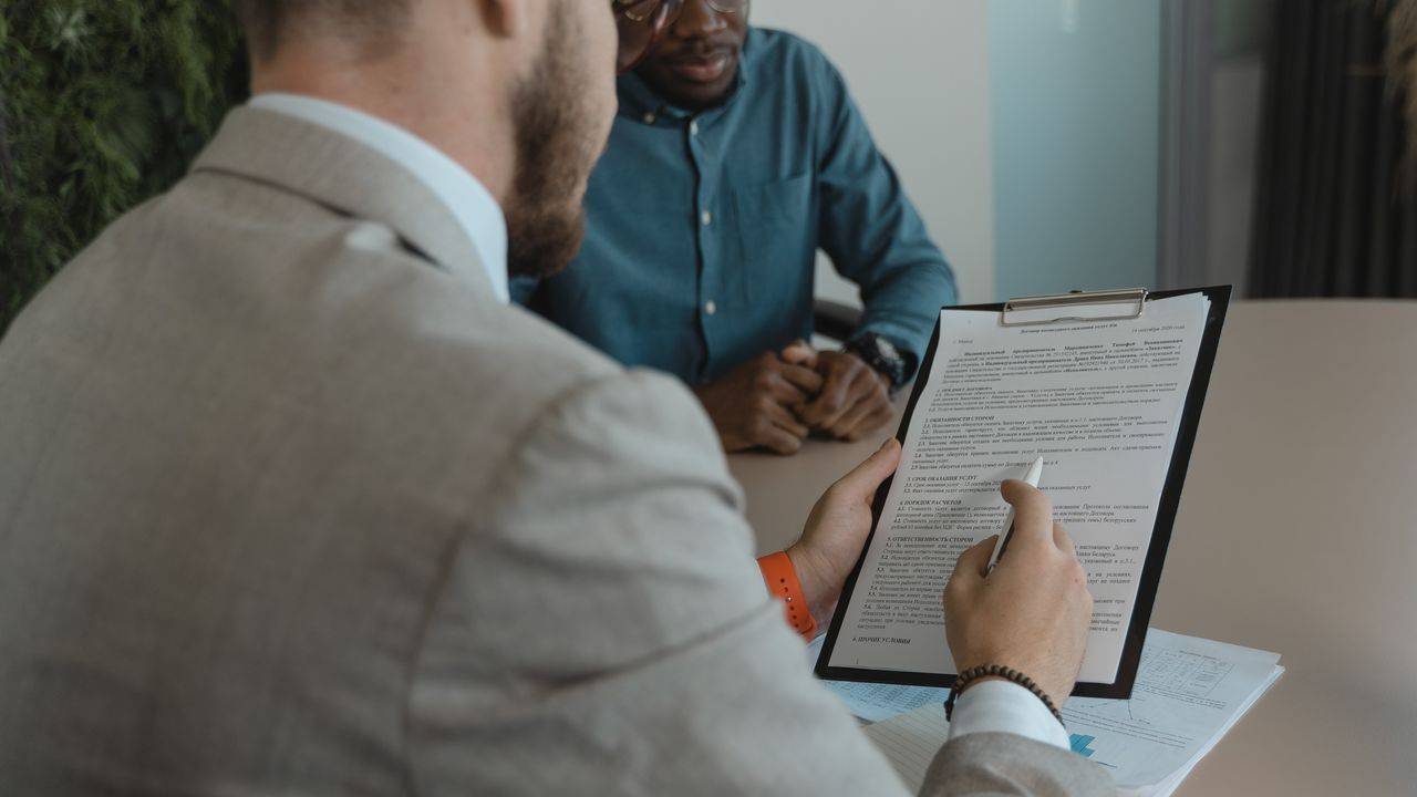Recruiter reviewing a candidate's CV on a clipboard during an interview
