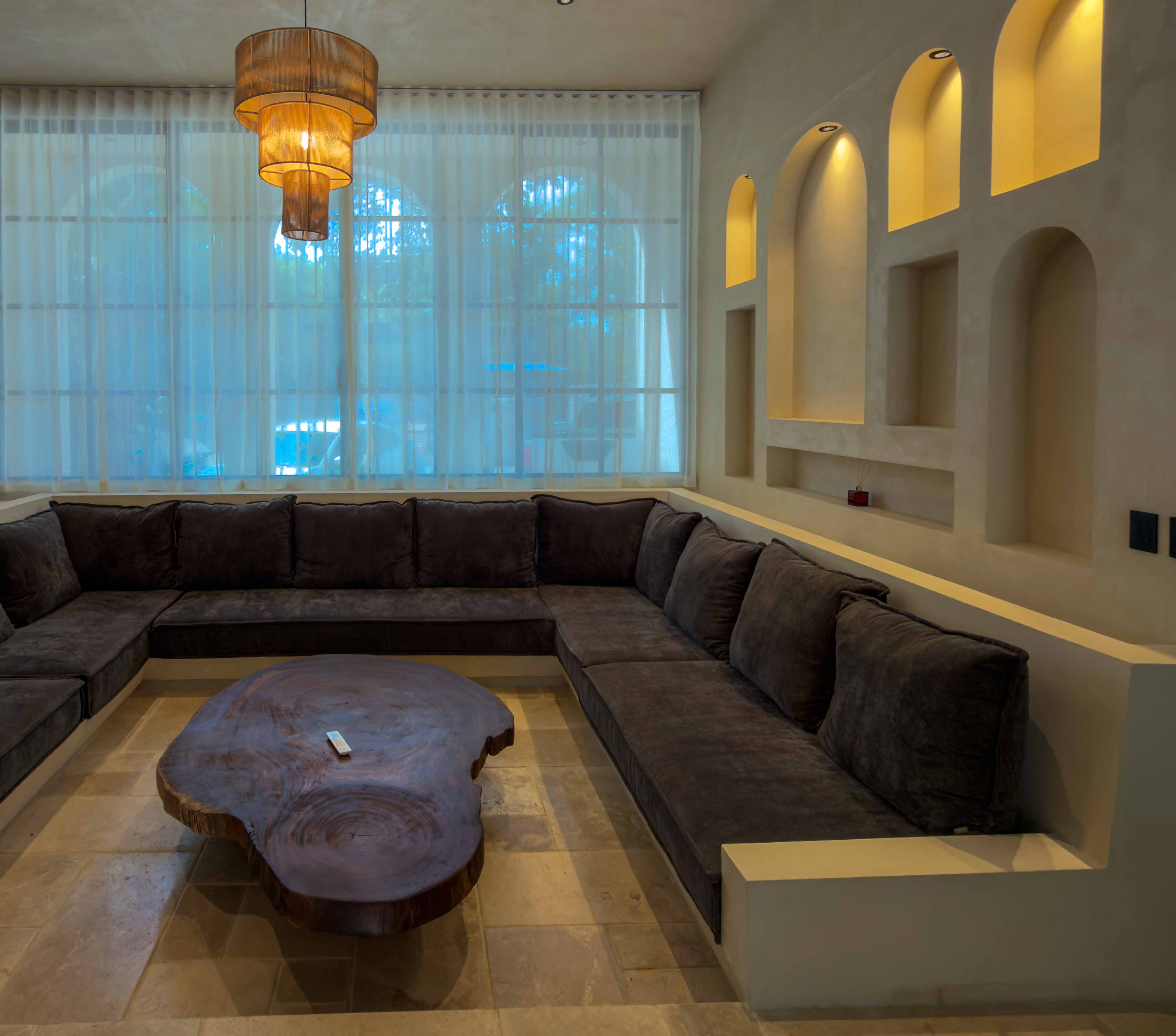 The sunken lounge with a live edge table and arched lit niches