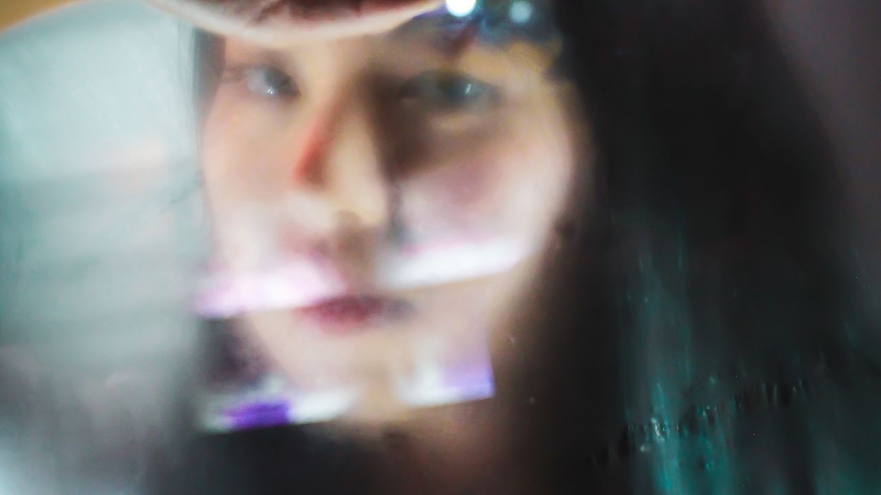 thoughtful woman gazing through a foggy window, evoking the stream of thoughts in IFS parts work