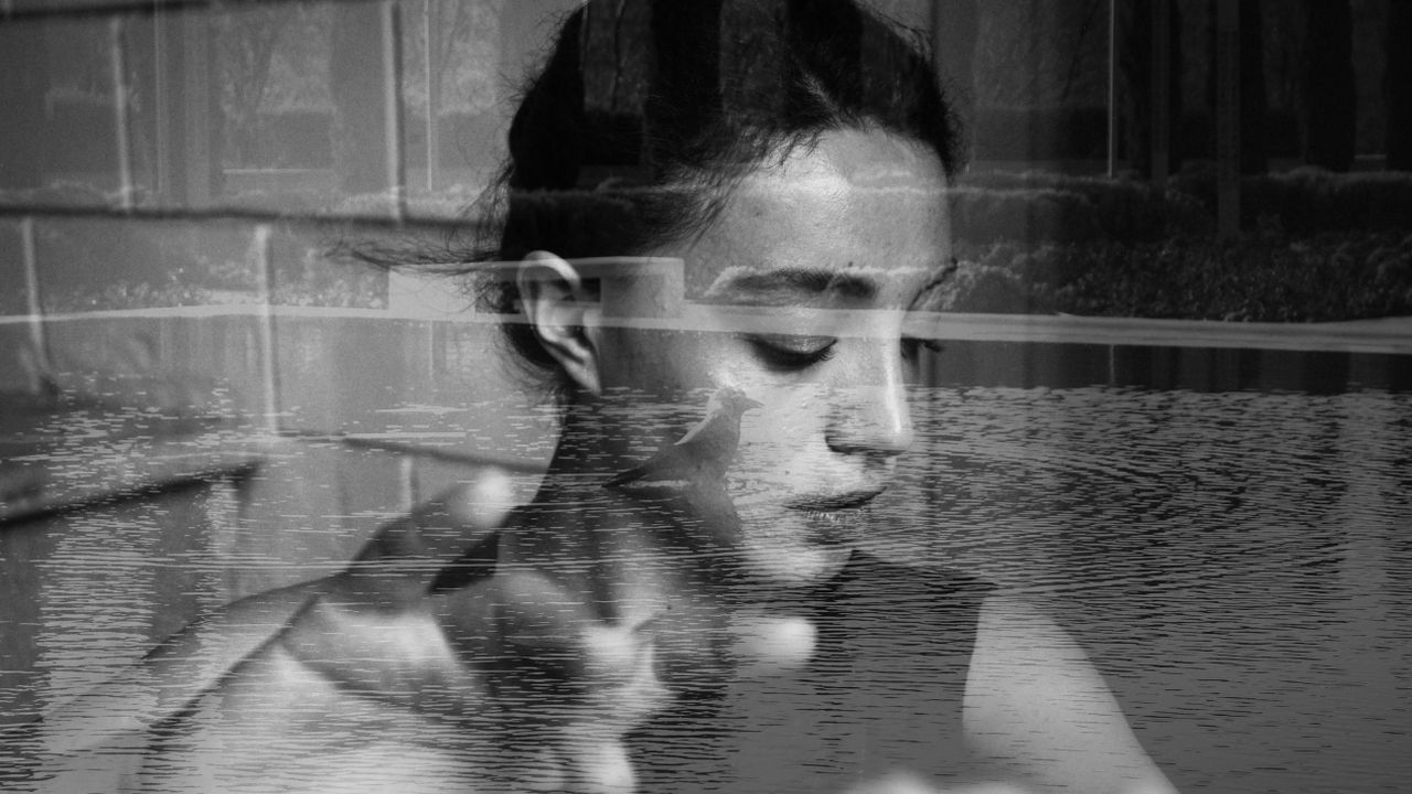 contemplative double exposure portrait of a woman, evoking inner parts and the question of whether they are real in IFS
