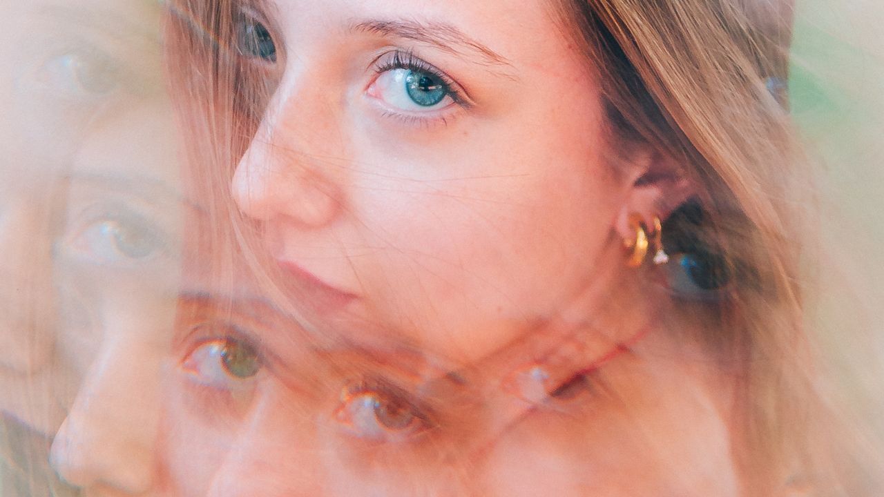 Multiple exposure portrait of a woman with overlapping expressions, illustrating examples of IFS parts — managers, firefighters, and exiles — within one person