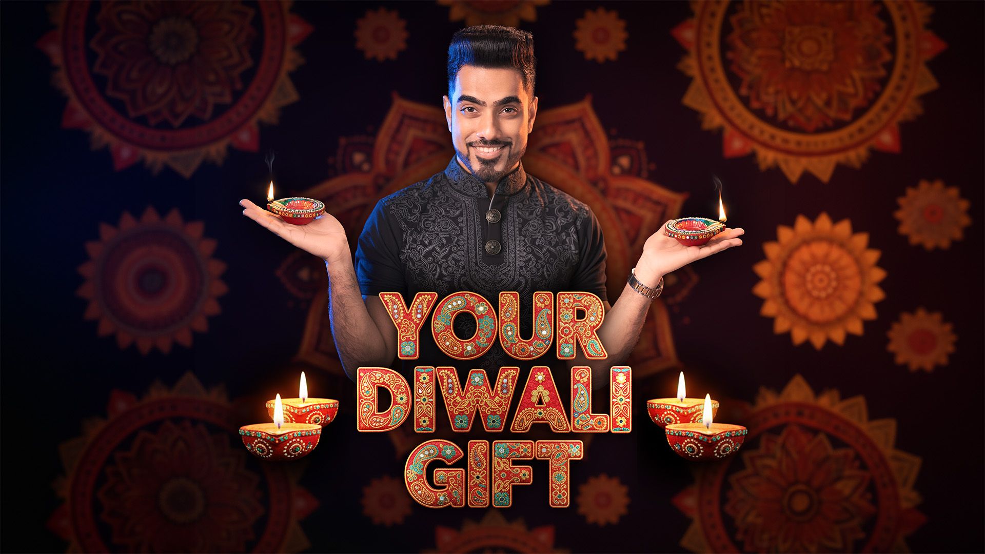 Your Diwali gift: Unmesh in a black kurta, smiling, holding a lit diya in each hand