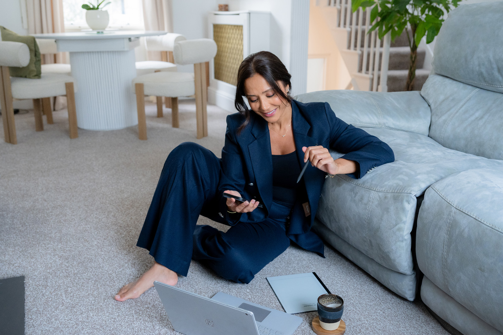 Dr Manrina Rhode working at her laptop, wearing a navy suit