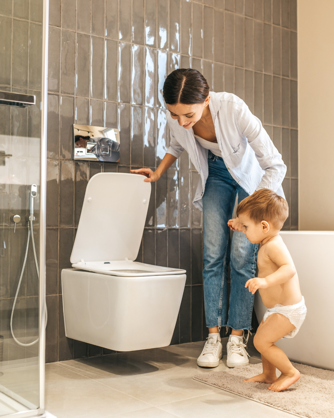 mother with toddler taking them to the toilet