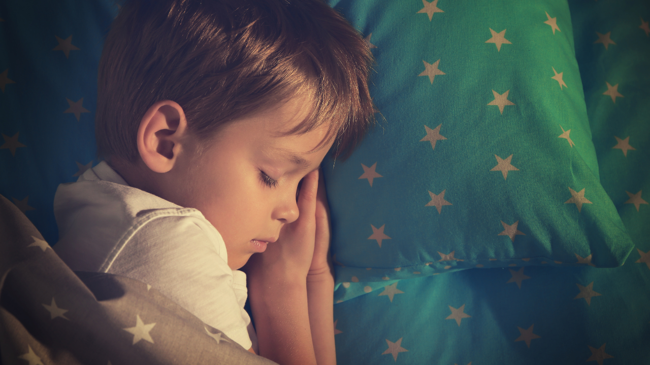 Toddler sleeping in bed with a nappy on