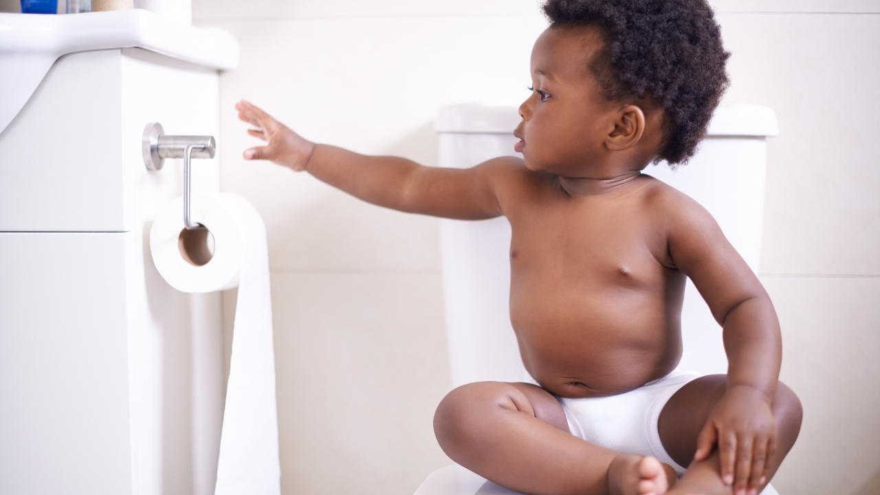 1 year old toddler sat on the toilet ready for potty training