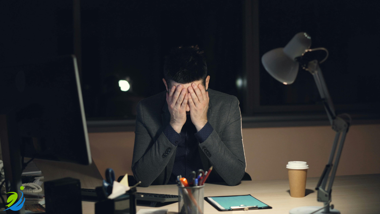 Restaurant owner sitting at a desk late at night with head in hands, showing stress and overwhelm after a potential workplace incident or business issue.