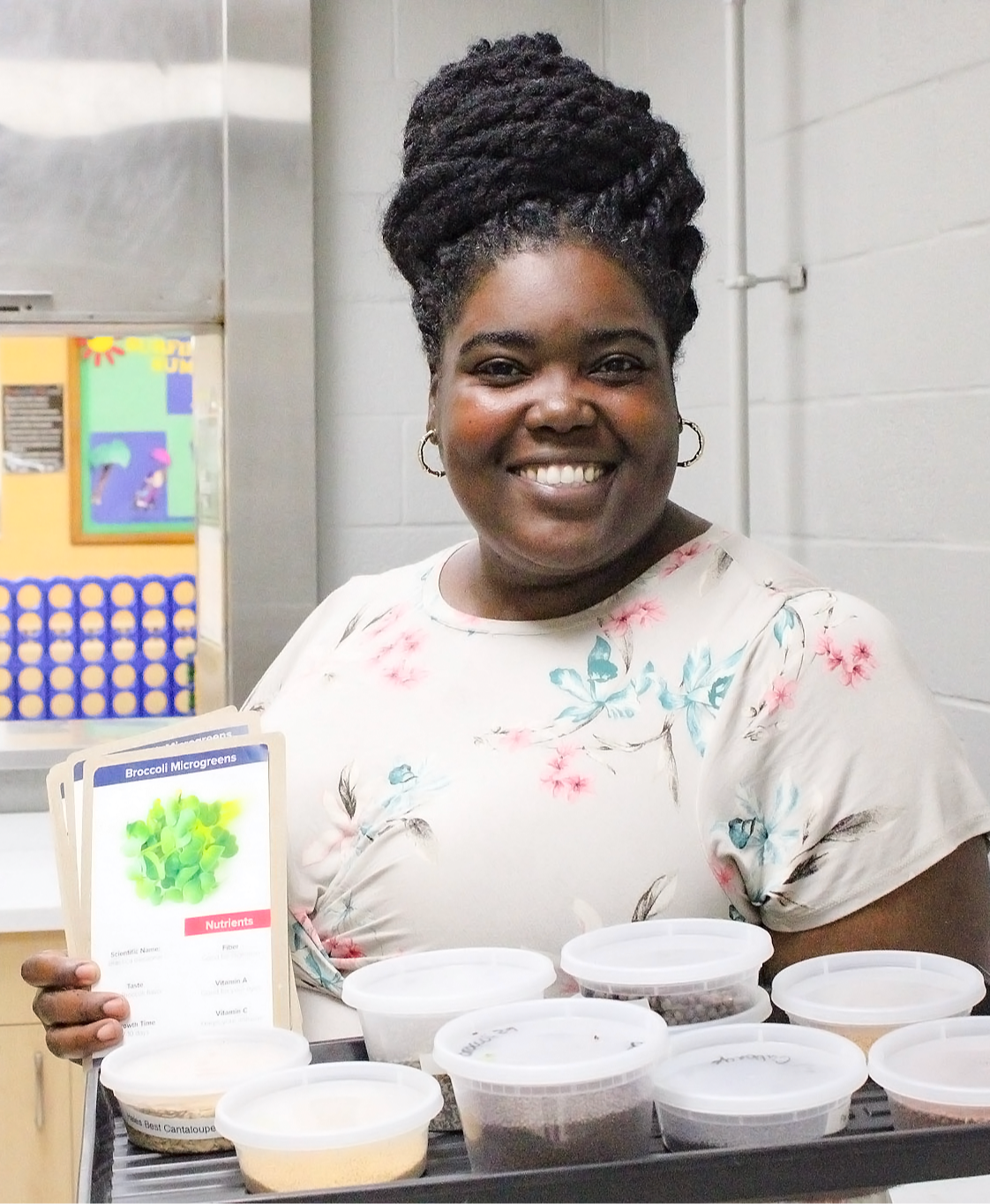 Quandra holding microgreens seed packets with sample containers