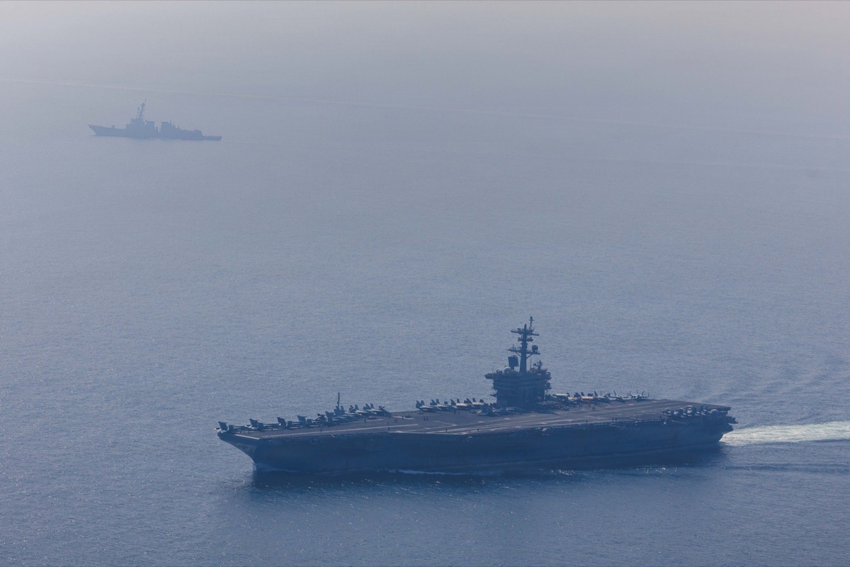 The aircraft carrier USS Abraham Lincoln and a destroyer at sea in the Arabian Sea