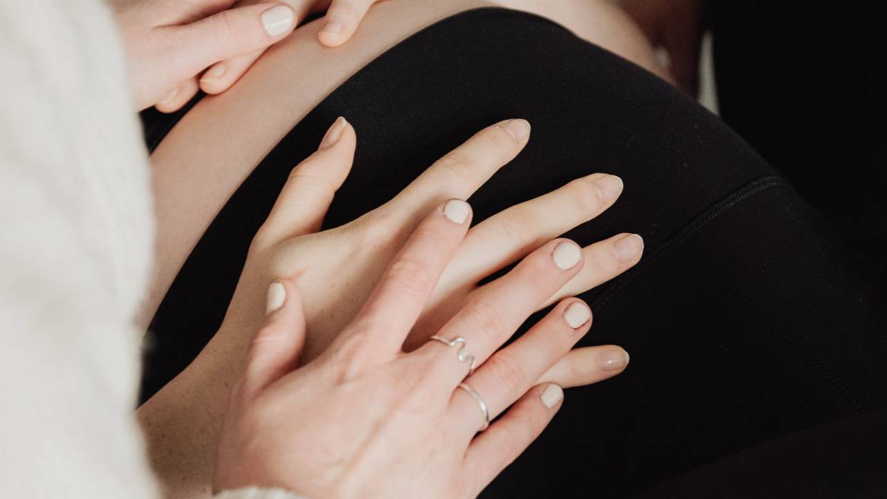 Femme enceinte tenant son ventre en fin de grossesse, avant un déclenchement de l'accouchement