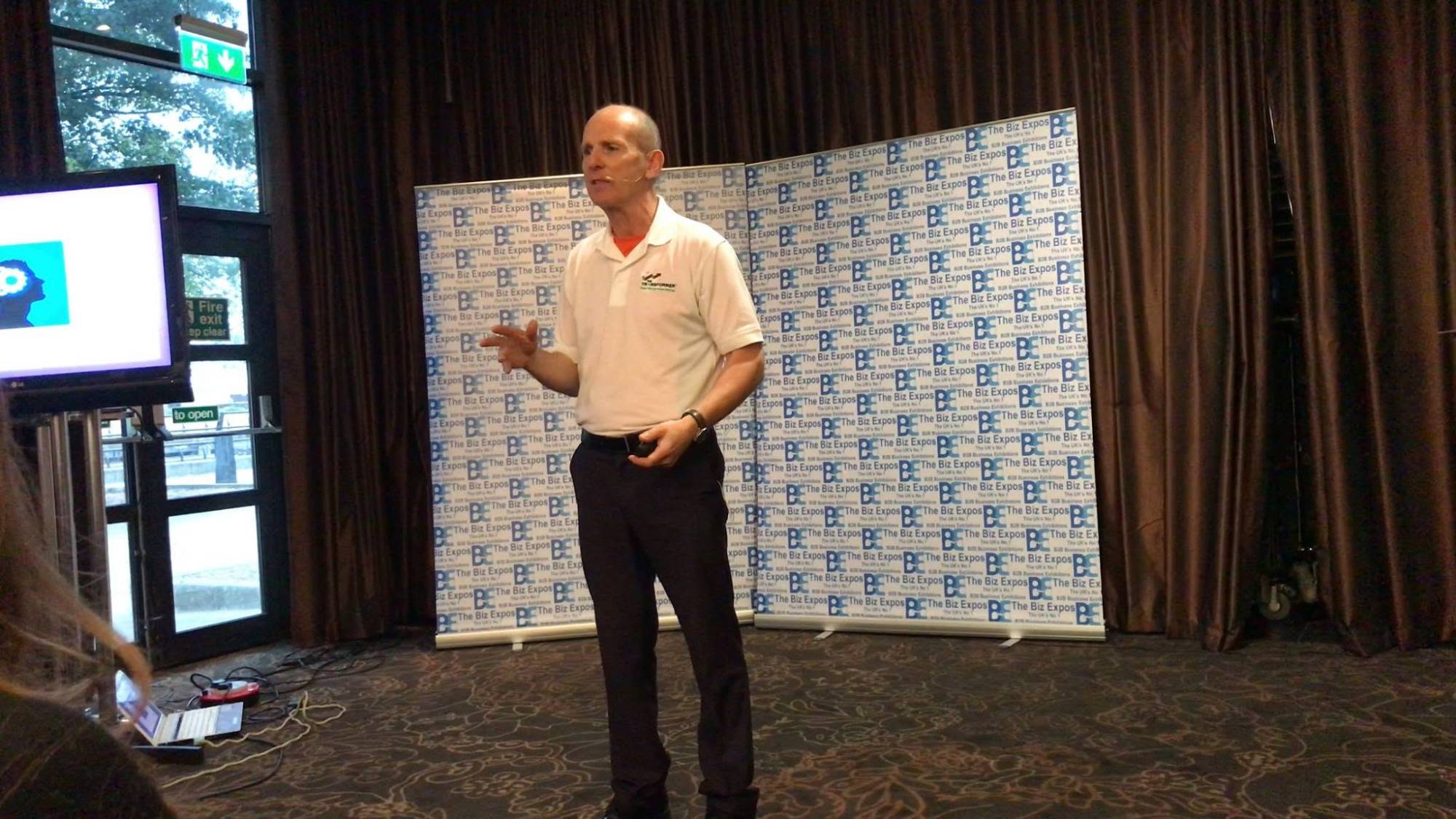 Joe O'Connor speaking on stage at a business expo
