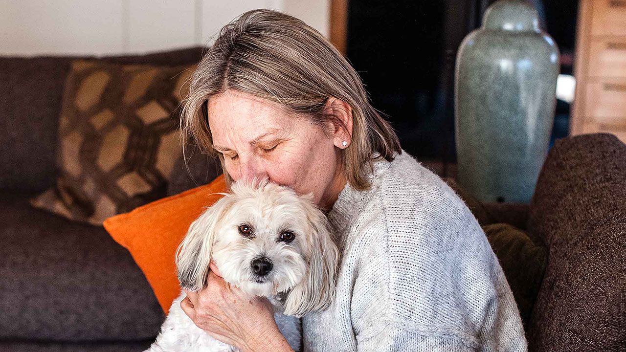 AHELP Project - Michelle Nichols blog post, Your Pet, Your Decisions — Navigating End-of-Life Care When You and Your Vet See Things Differently, photo of pet caregiver hugging her senior dog