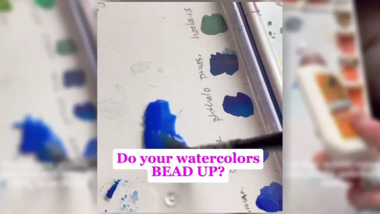 Juliene painting blue watercolor on a mixing palette, demonstrating why watercolor beads up on a palette and how to prevent beading for smoother color mixing.