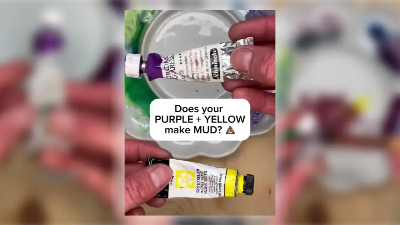 Juliene holds purple and yellow watercolor paint tubes over a palette, demonstrating why mixing purple and yellow can create muddy gray watercolor colors.