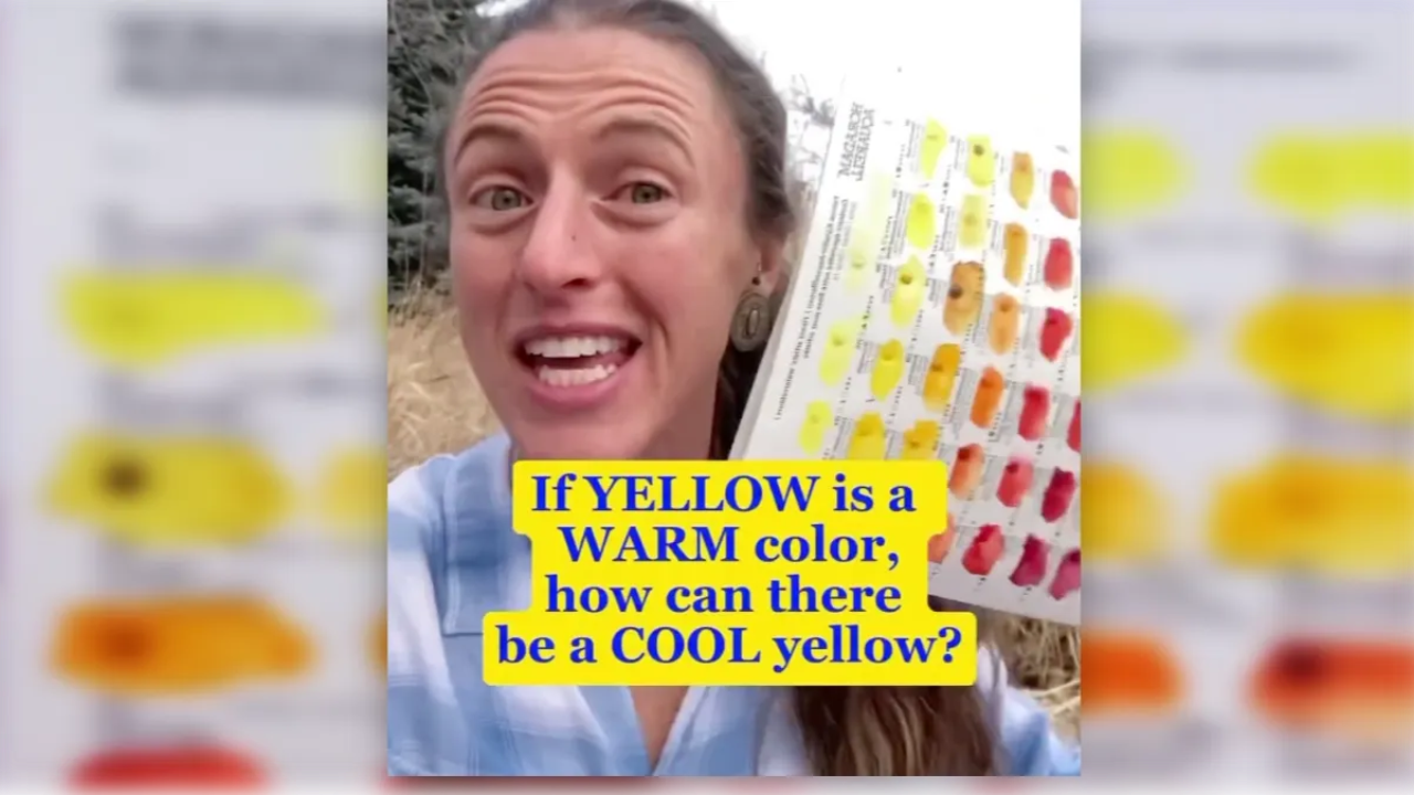 Juliene holding a watercolor swatch chart with yellow, orange, and red samples, explaining the difference between cool yellow and warm yellow in watercolor.