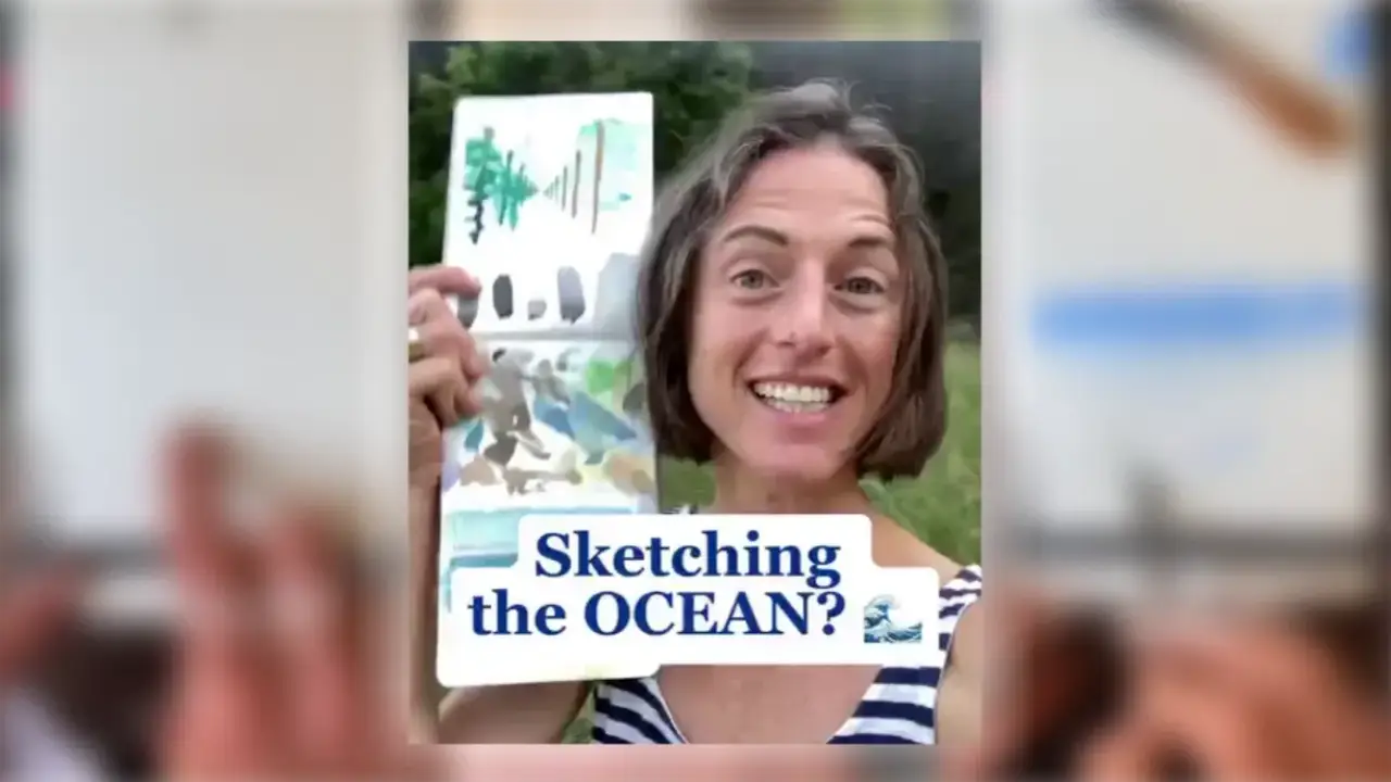Artist Juliene smiling and holding a watercolor sketchbook with ocean-inspired color swatches, introducing a watercolor ocean sketching tutorial on how to paint a straight horizon line.