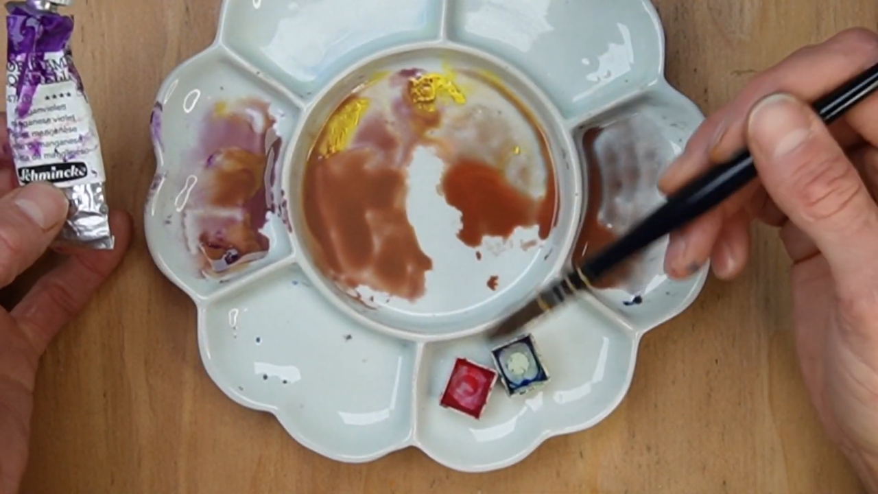Watercolor palette showing muddy paint mixtures and color mixing demonstration.