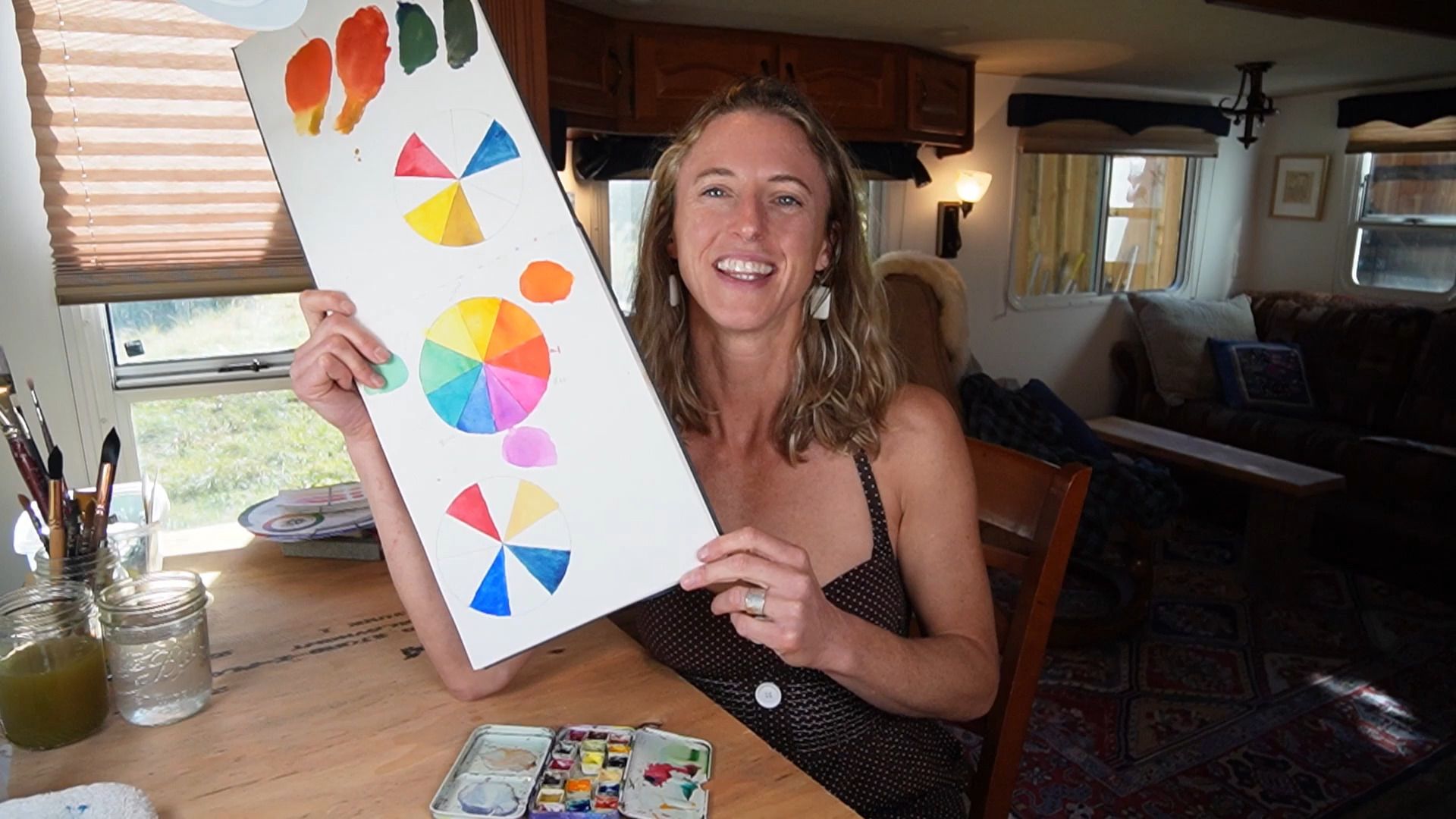Juliene, a watercolor artist displaying color mixing studies to explain how color bias affects paint mixtures.