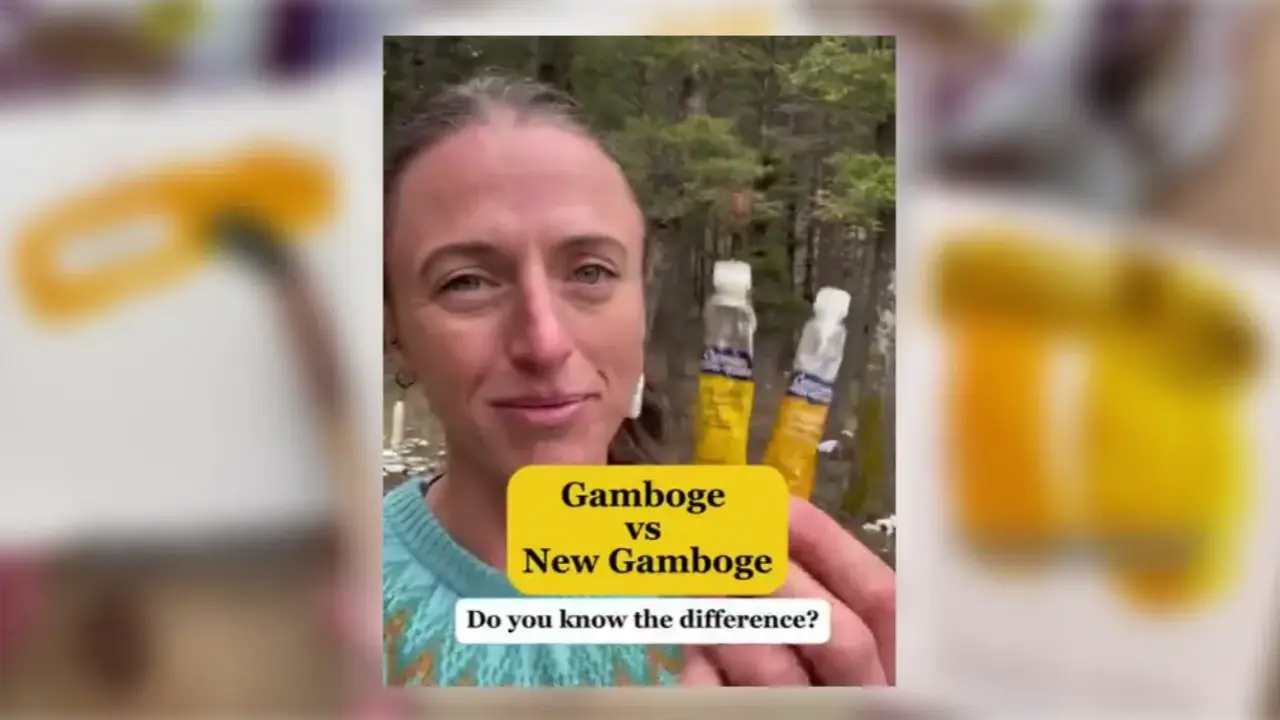 Juliene holds two yellow watercolor paint tubes outdoors, comparing Gamboge and New Gamboge to explain the differences between these watercolor pigments.