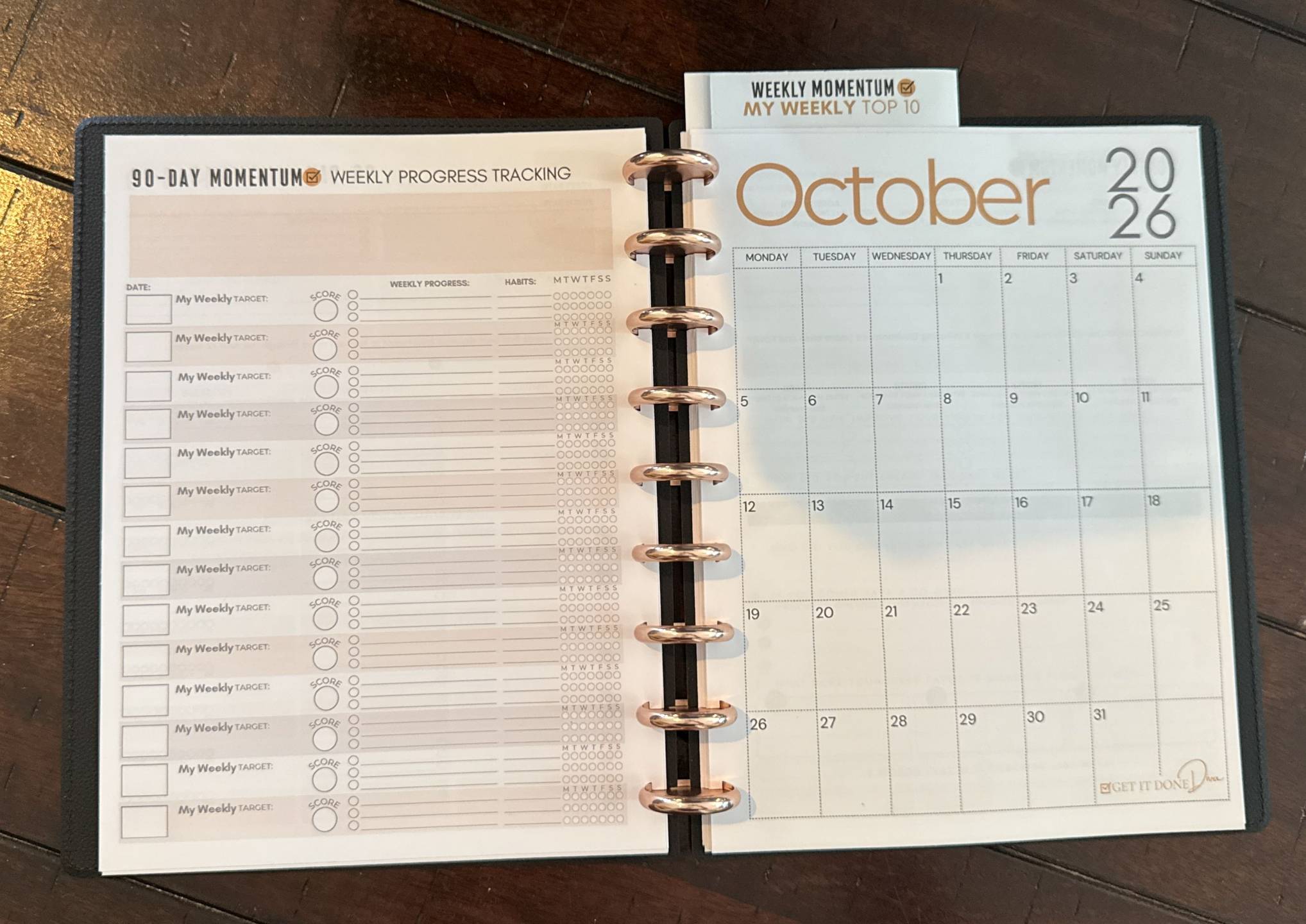 Closed planner showing the black vegan-leather cover and rose-gold discs