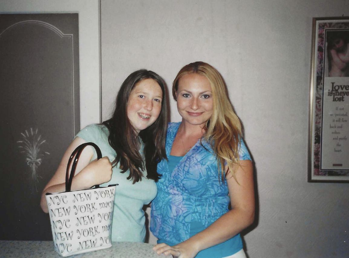 A younger Miranda smiling next to a girl holding a New York tote bag