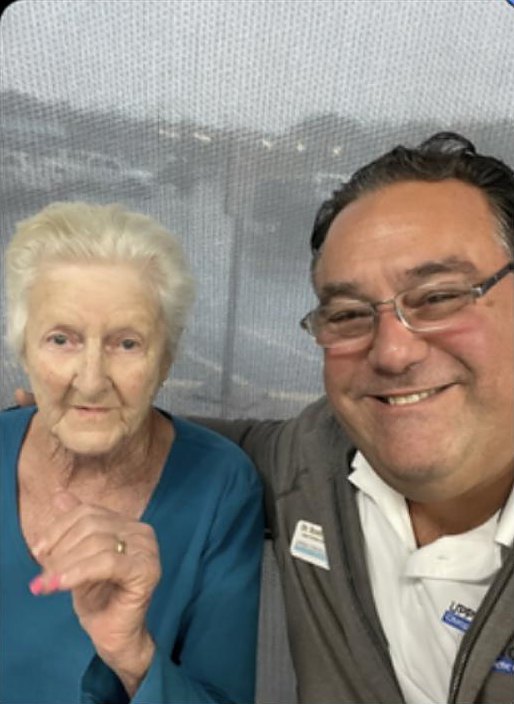 Grandma Brunhilda smiling next to Dr. Scott Baker at his office