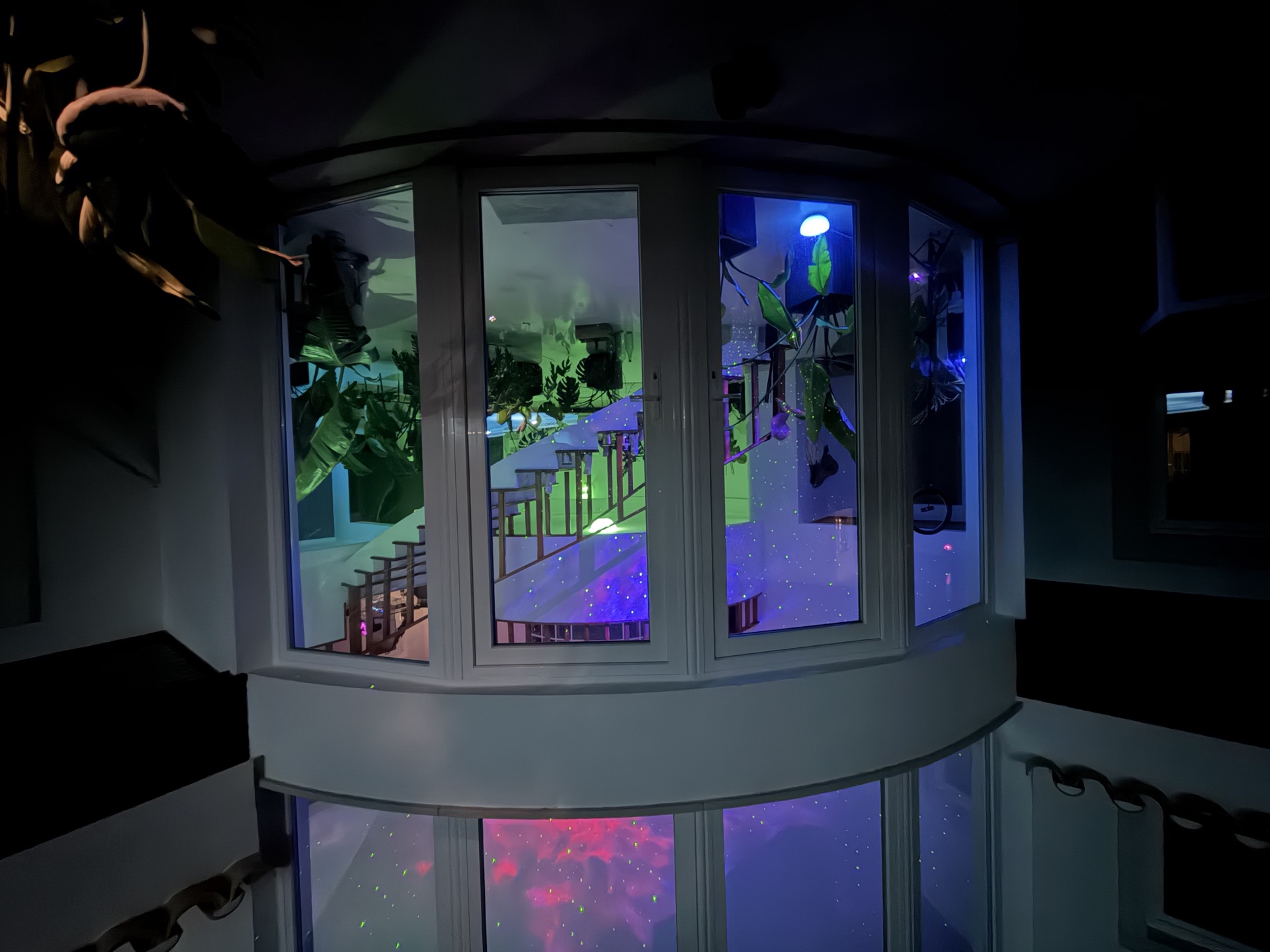 Night view of the Living Lab glass tower, lit by a projected starry sky