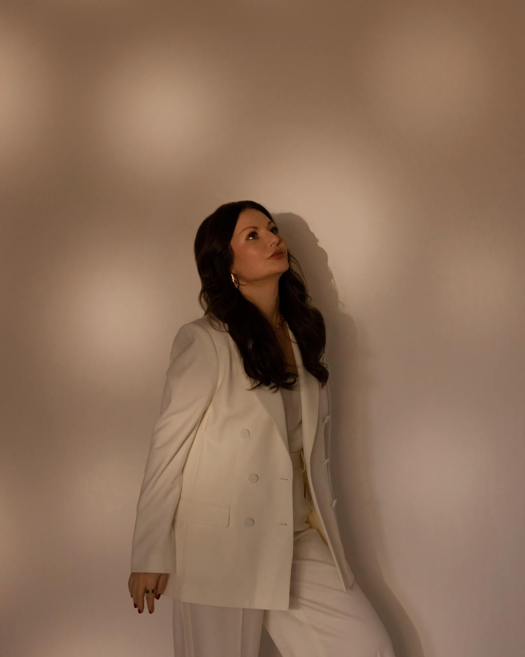 Gabriella Testa, founder of Welltality Coaching®, wearing a cream suit for Luxury Longevity Coaching™