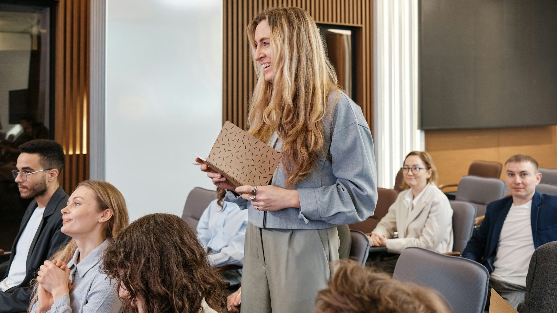 woman standing in middle of group of people speaking