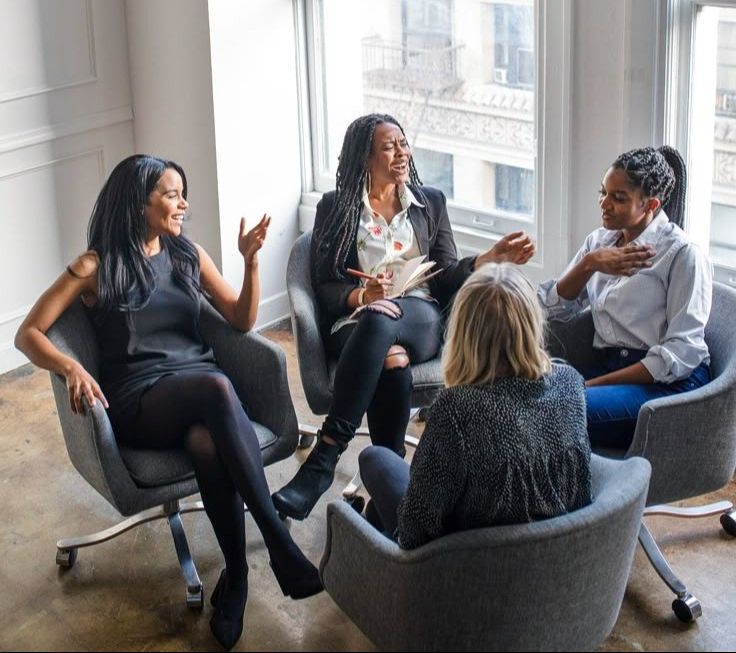 4 people talking in a circle in office