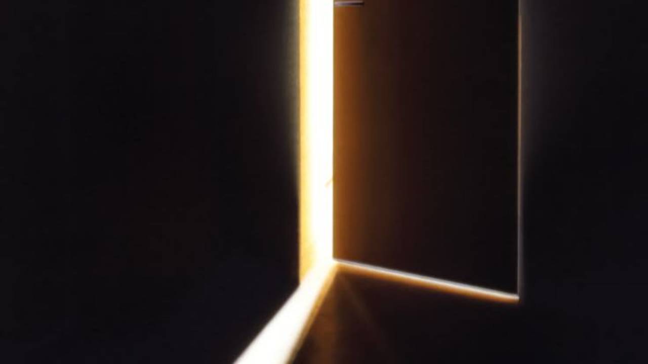 dark room with a door cracked light shining through