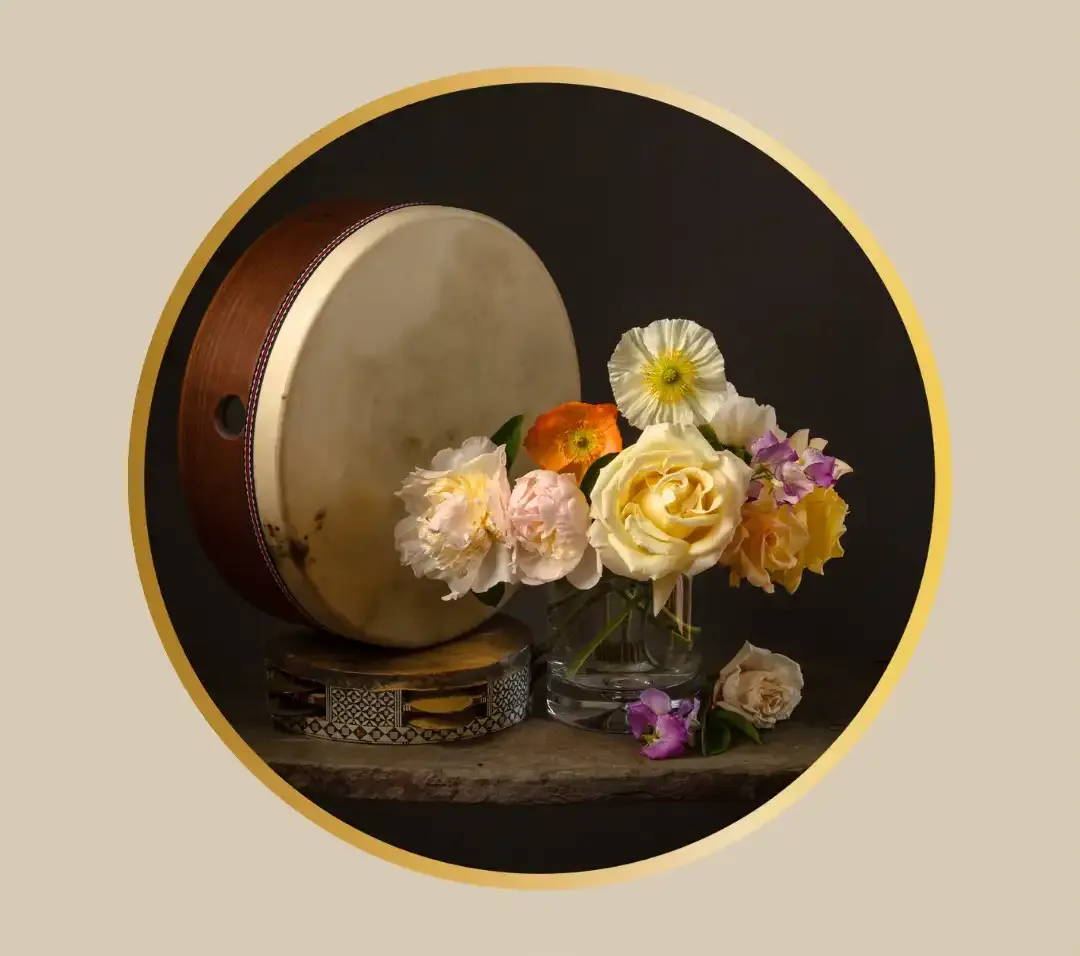 A beautiful still life with a frame drum and a bouquet of flowers