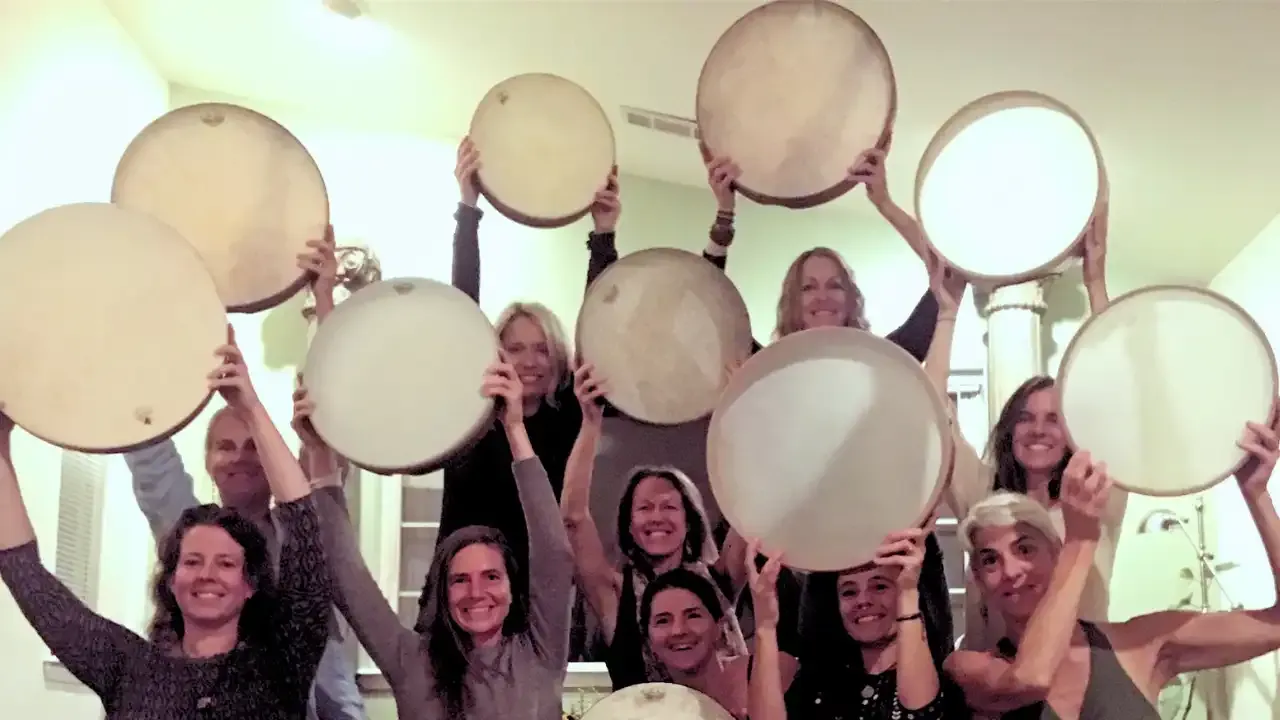 Krista Holland with women holding frame drums up in the air width="1280" height="720"px
