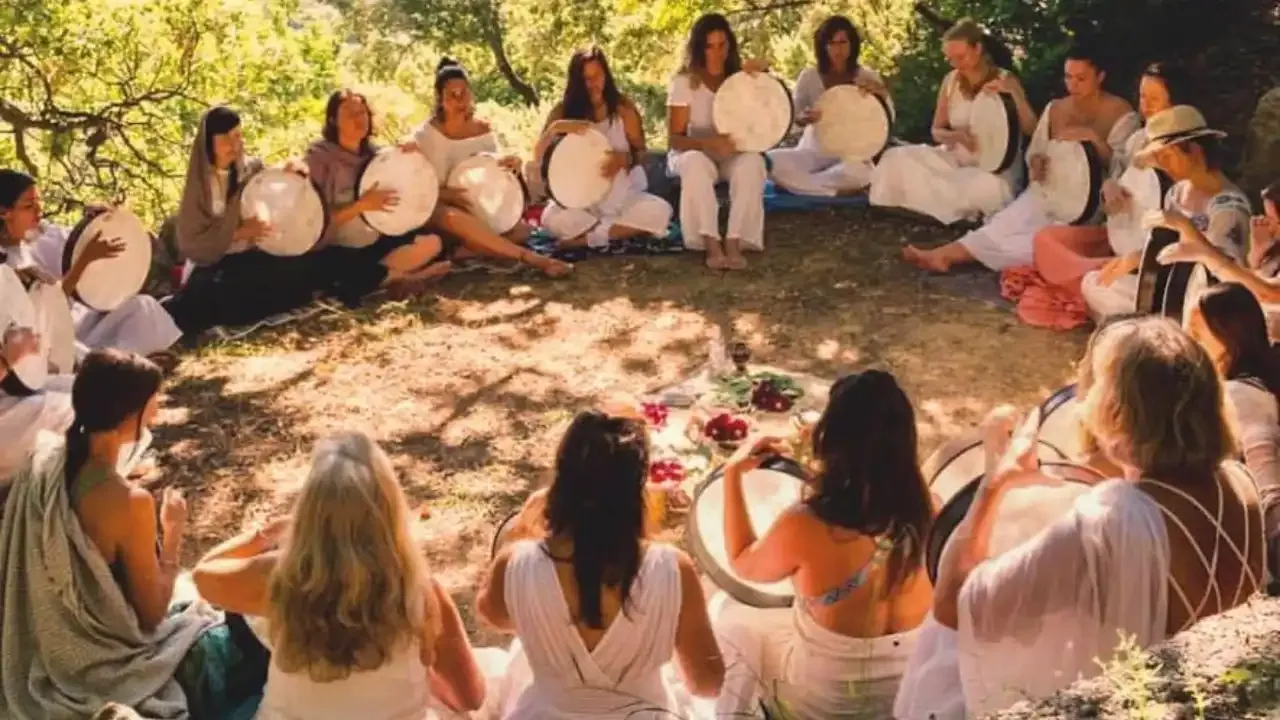  Krista Holland in Crete, Greece with a group of women sitting in nature in a circle playing frame drums with Krista Holland in Greece 