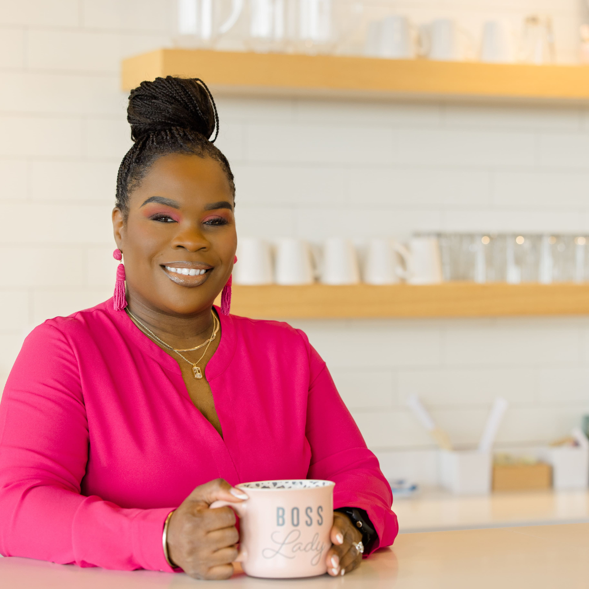 Latisha Newby seated at a counter holding a mug
