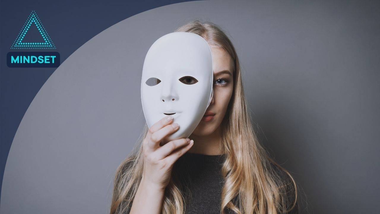 Woman holding a white mask, symbolizing mindset, identity, self-awareness, and personal transformation.