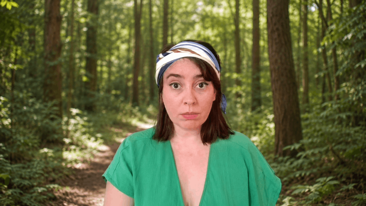 Sofiea is standing in a forest. It is spring time and the forest is blossoming.